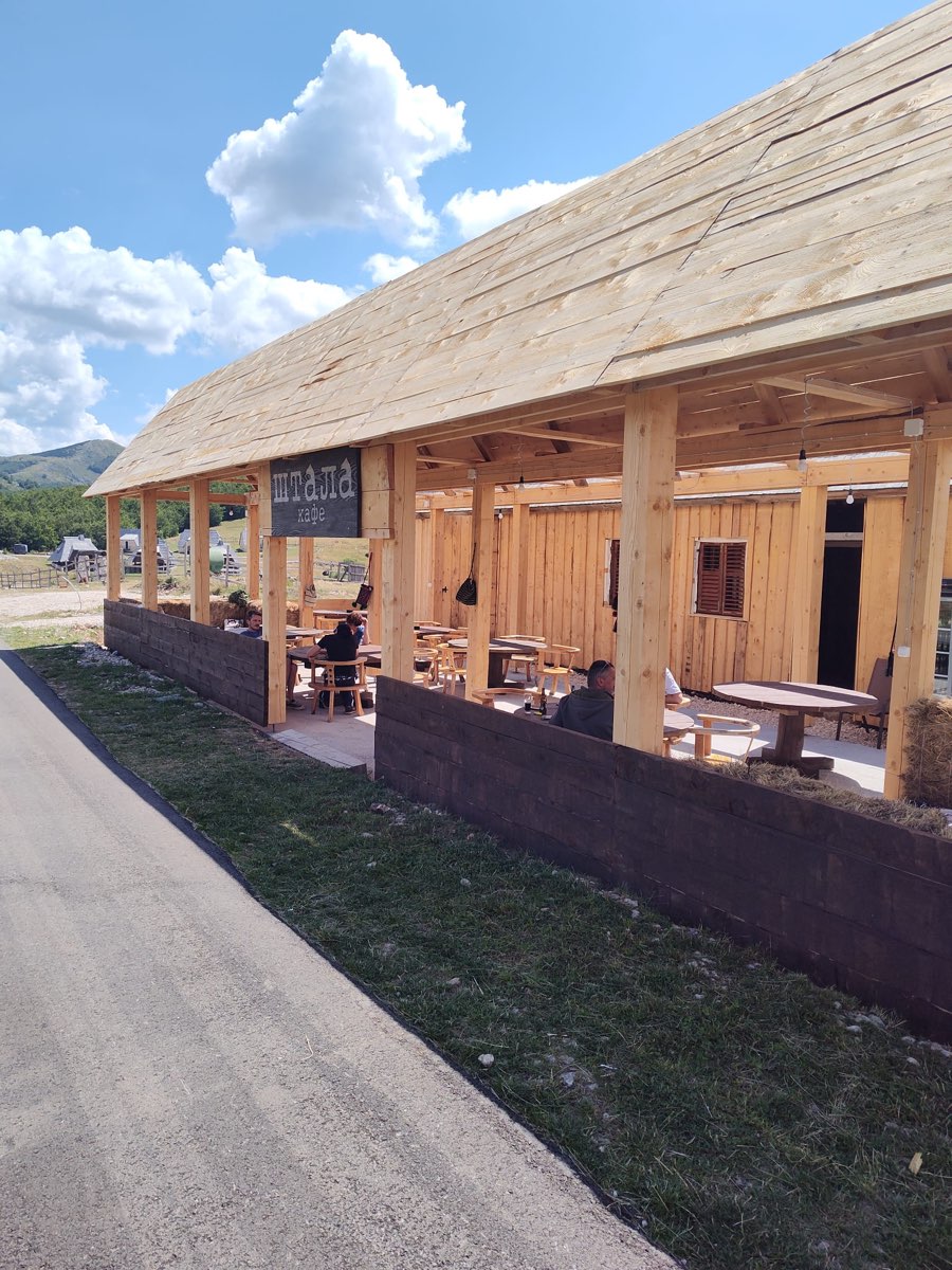 Štala Kafe — the timber-roofed café bar with guests on its terrace