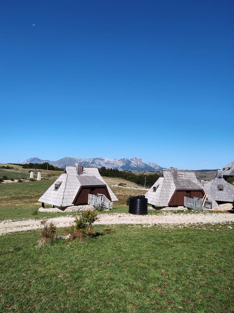 The village houses on the open plateau with the Durmitor massif behind